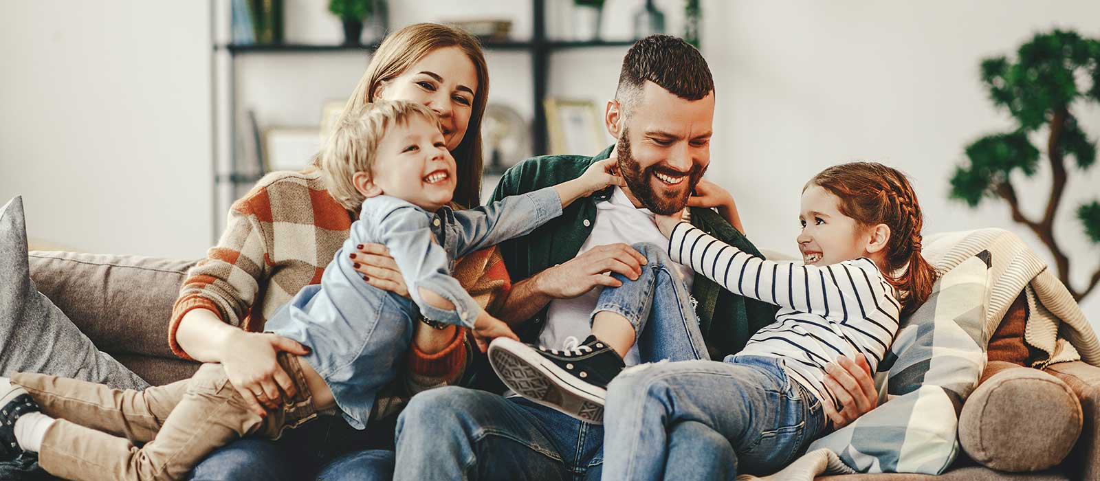 happy family mother father and kids at home on couch